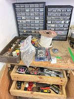 Workbench showing two drawer cabinets, open wooden drawers with tools