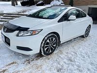 Front and side view of white 2013 Honda Civic Coupe in snow