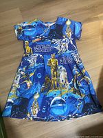 Front view of blue Star Wars print dress laid flat