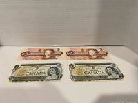 Fronts of two $1 and two $2 Canadian banknotes displayed together