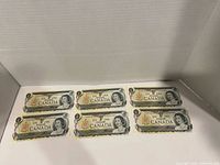 Front view of six 1973 Canada $1 notes laid flat