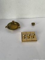 Group shot of ashtray, stamp base and folding loupe