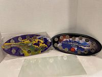 Two oval 2000 Millennium coin sets side by side