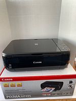 Printer resting on original box, lid closed