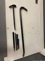 Overall view of two pry bars and four chisels on white background