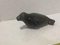 Left side view of dark green soapstone seal sculpture