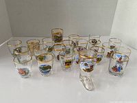 Full set of gold-rim souvenir shot glasses including boot glass