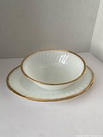 Bowl nested on platter showing color, fluted rims, gold trim