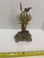 Full view of stone chip sculpture on rock base with measuring tape