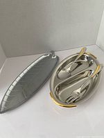 Leaf-shaped tray beside divided serving platter holding spoon and fork