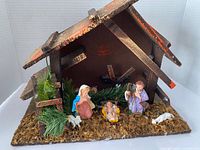 Front view of stable with moss and three displayed figures (Mary, Joseph, infant Jesus) plus sheep