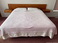 Full view of assembled king bed with teak headboard and twin nightstands