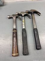 Front view of three claw hammers showing handles and heads
