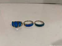 Front view of three sterling silver rings showing opal inlay and pavé crystals