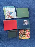 All six books laid out on blue carpet