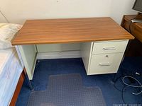 Full view of desk showing laminate top, metal frame, two-drawer pedestal