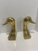 Front profile of both brass duck head bookends
