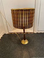 Full view of lamp showing base, stem and woven shade