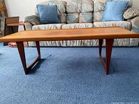 Front view of teak coffee table showing legs and overall form