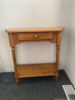 Front view of oak hallway table showing drawer, legs, shelf