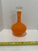 Full view of decanter with stopper and measuring tape indicating height