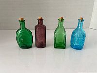 Front view of all four coloured bottles standing in a row