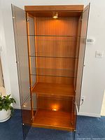Cabinet doors open showing glass shelves and interior lights