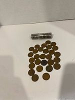 loose Wheat Cents arranged beneath clear plastic coin tube