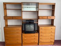 Front view of full modular wall unit showing dressers, shelves, glass cabinet