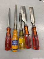 All five chisels front view, handles and blades visible