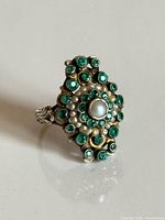 Top view showing pearl center, seed pearls, green stones