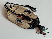 Full view of beaded purse showing shape, cords, tassel