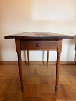 full side view of pine table showing drawer and turned legs