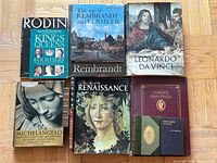 Six large art books and small booklet laid out