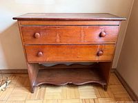 Front view of pine chest showing two drawers, knobs, and shelf