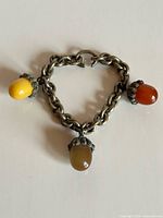 Full view of bracelet showing chain, three Bakelite acorn charms and clasp