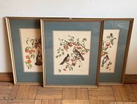 All three framed prints standing against wall