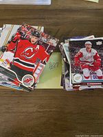 Two stacks of assorted hockey trading cards showing top cards of New Jersey Devils and Detroit Red Wings players
