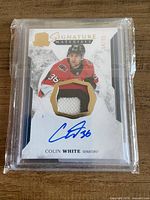 Front view of encapsulated Colin White Signature Materials card showing autograph, patch, serial number