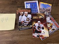 All six pocket schedules fanned out on tabletop showing covers and seasons