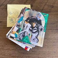 Angle view of stacked hockey cards on wooden surface, top card Parkhurst Johan Hedberg