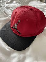 Front angled view showing red crown, black brim and silver Jumpman logo