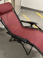 Red zero gravity chair folded open showing seat, headrest, frame and lacing