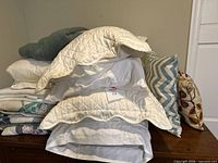 Stack showing quilt, bed pillows, shams, teal pillow, chevron and botanical pillows