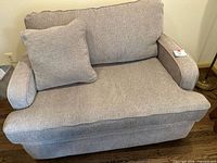 Front view of beige-grey sleeper sofa with cushion
