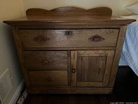 Front view showing entire oak chest, drawers, cabinet door, knobs