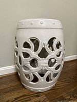 Front three-quarter view of pierced white ceramic garden stool