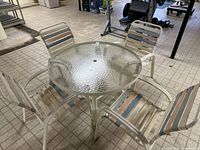 Full view of glass patio table with four chairs