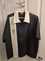 Front view of shirt showing two-tone design, zipper, logo and pocket