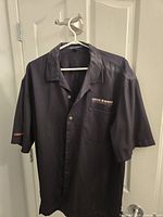 Front view showing button front, chest embroidery, sleeve text